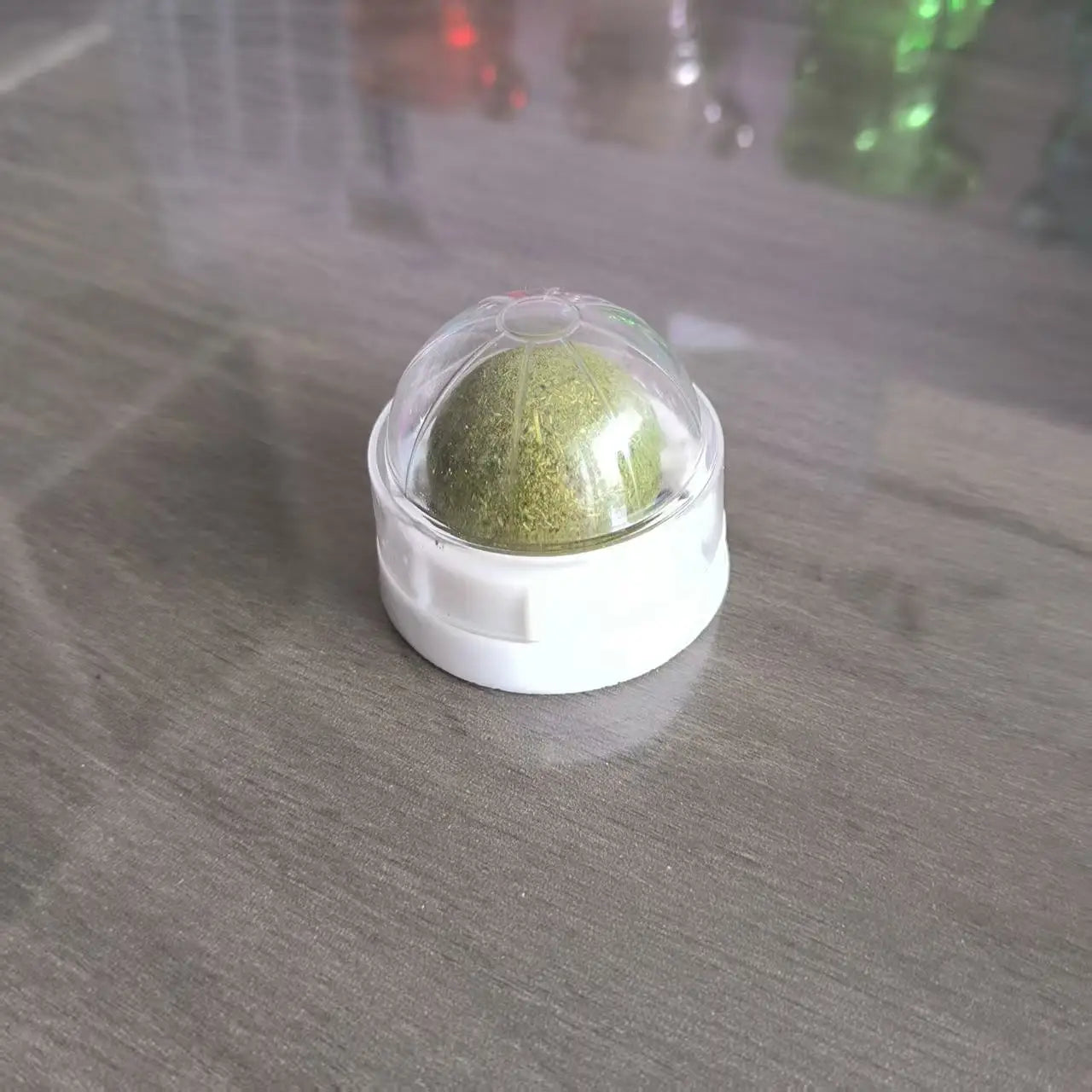 Balle de friandise catnip collée sur un meuble