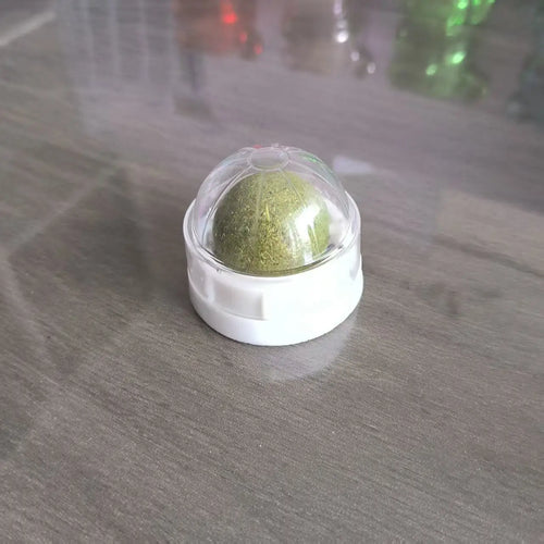 Balle de friandise catnip collée sur un meuble